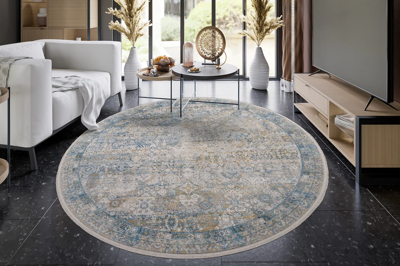 Ein traditioneller, klassischer, blau und beiger runder Teppich mit Fransen liegt im Wohnzimmer auf dem Boden. - Ein traditioneller, klassischer, blau und beiger runder Teppich mit Fransen liegt im Wohnzimmer auf dem Boden.